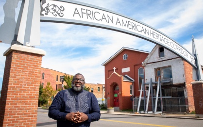LaGarrett King standing in front of the African American Heritage Corridor. 