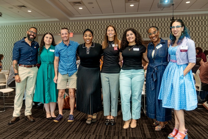 A group of higher education professionals stand together for a photo. 