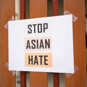 Sign taped to a fence stating "Stop Asian Hate.". 