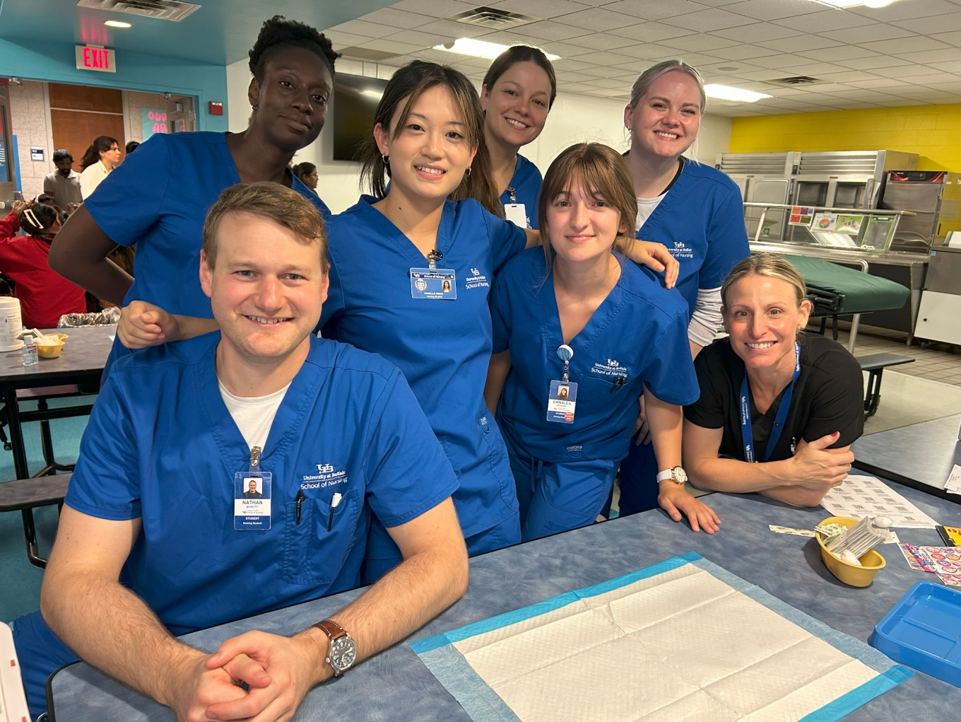 Students in scrubs pose in elementary school classroom. 