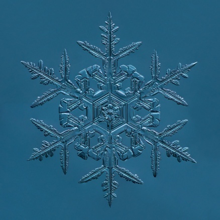 A single snowflake on a blue background. 