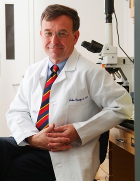 John Canty in white coat, seated. 