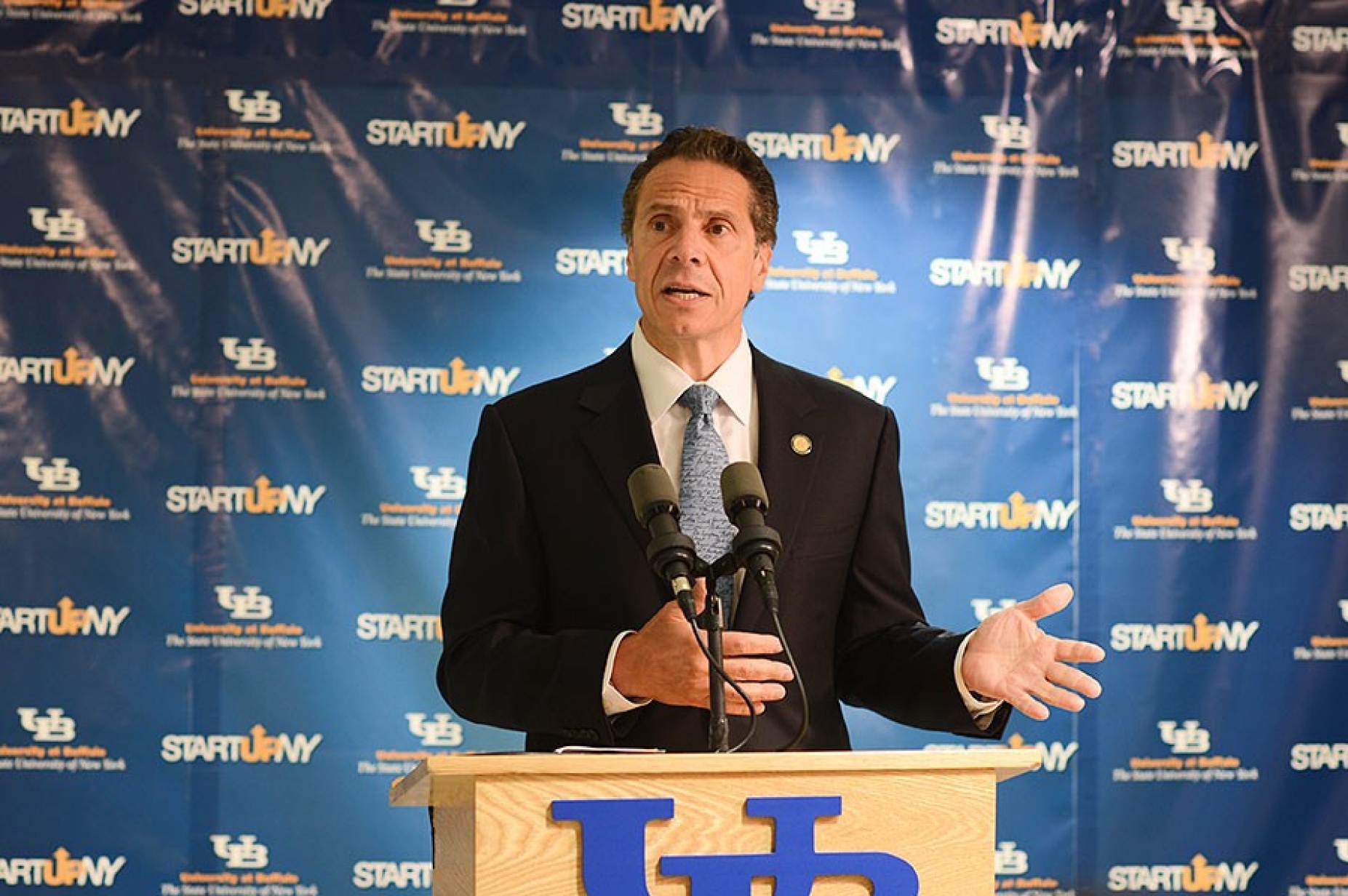 Gov. Andrew M. Cuomo speaking at a podium at UB to announce that eight additional companies will relocate on or near the UB campuses through their participation in Start-Up NY. 