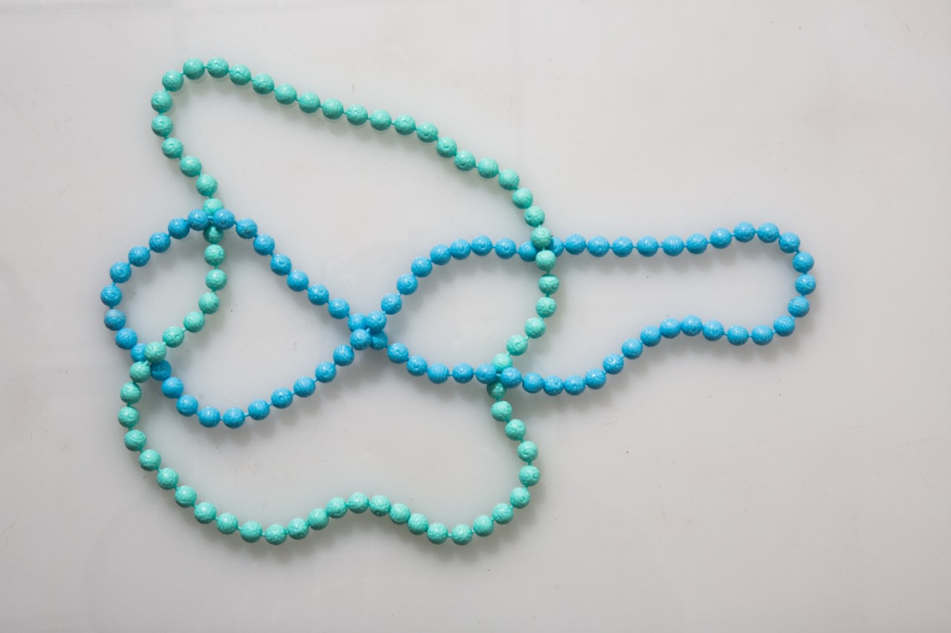 Two interlocking strings of beads.