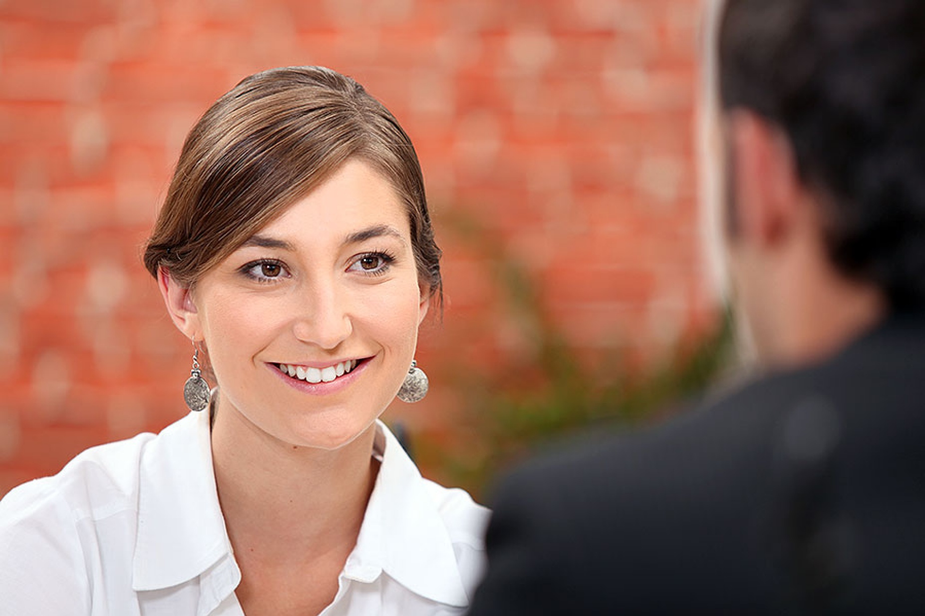 A woman on a date looks at a man who has his back to the camera. 