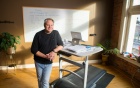 Donald Jacobs standing next to his treadmill desk. 