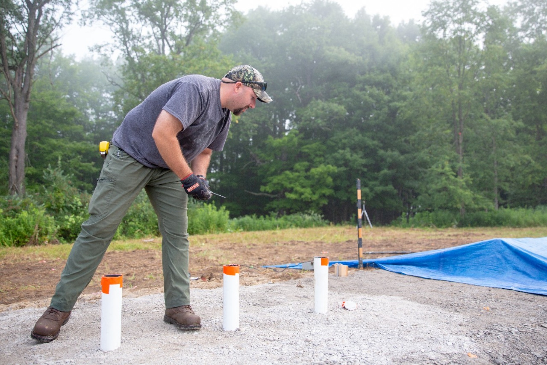 Zoom image: Andrew Harp, a recent UB geology PhD graduate, works on a blast pad. The white tubes mark locations where explosive charges will be placed. Harp helped to plan the workshop. Credit: Meredith Forrest Kulwicki 