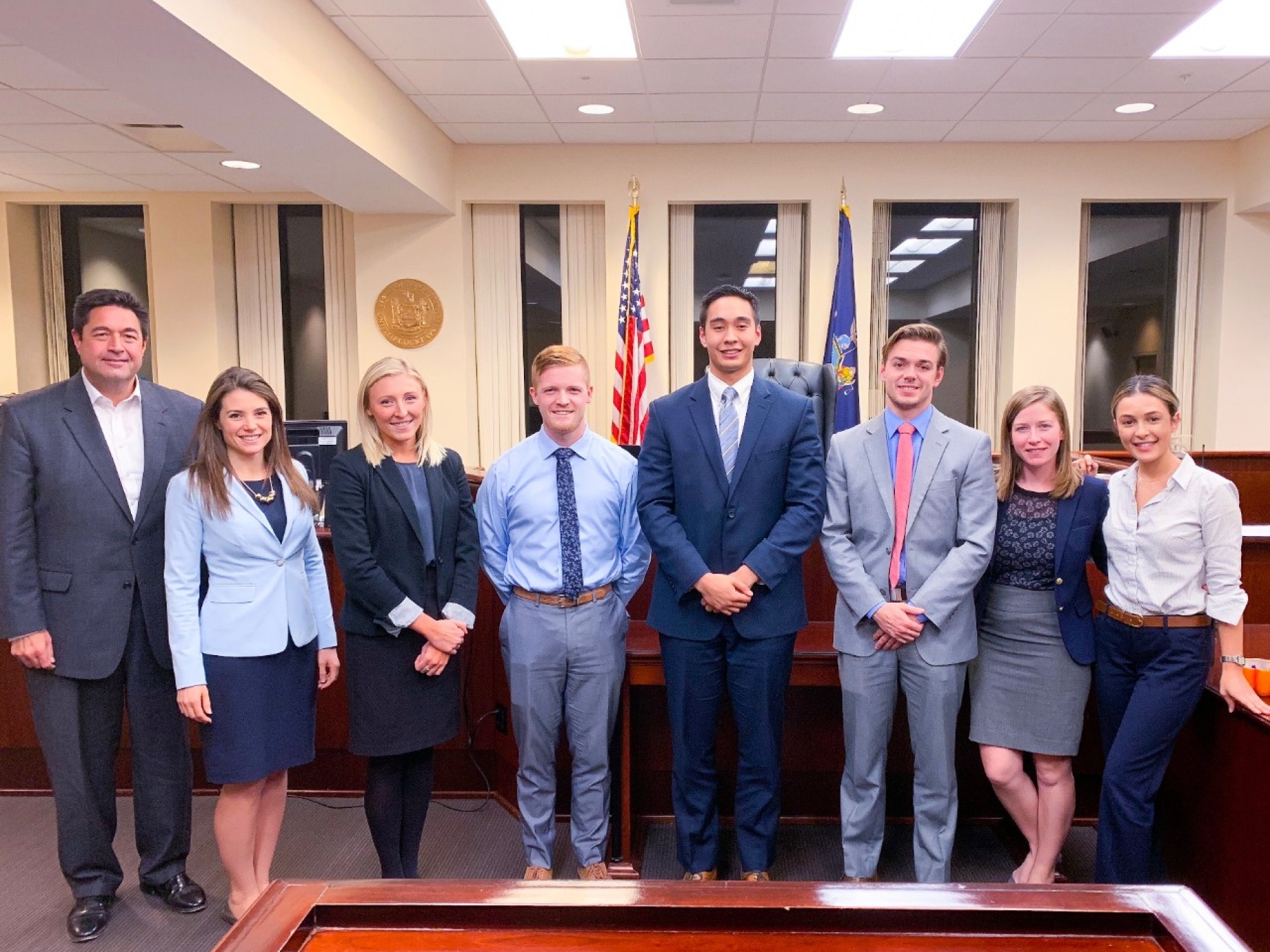 Members of the UB law school's Mock Trial Competition team pose together in a court room setting. 