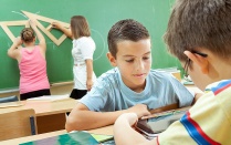 Elementary school students at classroom desks. 