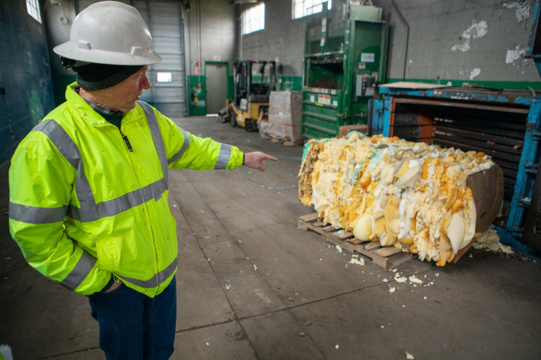 Zoom image: John Hannon, co-owner of Triad Recycling and Energy, discusses how the company picks apart used mattresses to repurpose parts including foam, which is later used by another business to make carpet padding. Hannon has been working closely with UB students through the carbon reduction class. Credit: Douglas Levere / University at Buffalo 