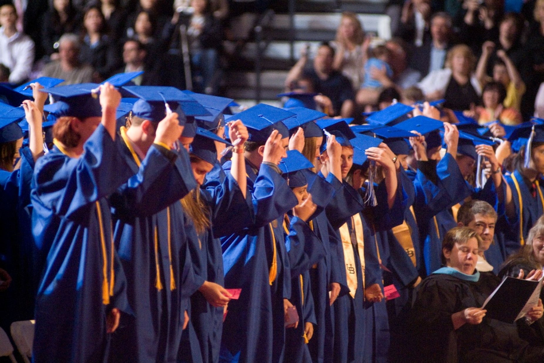 students adjust their tassels at commencement.