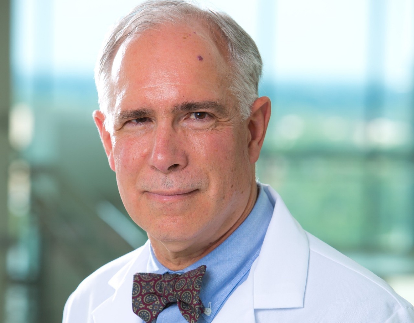 Headshot of James Jarvis in a white coat. 
