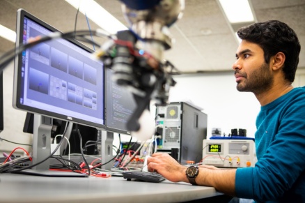 Zoom image: Sri Sadhan Jujjavarapu, University at Buffalo PhD student in mechanical and aerospace engineering, views digital data showing how the robotic gripper moves. Credit: Douglas Levere / University at Buffalo 