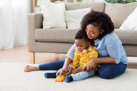 A mother and child playing in a living room-type setting. 