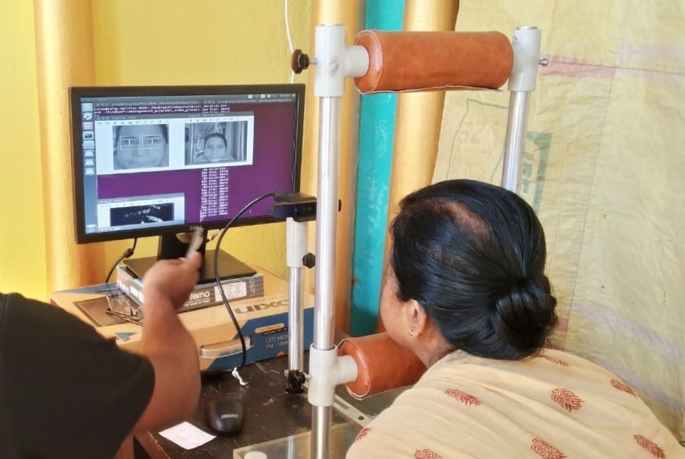 A person seated and looking into an infrared camera positioned at a computer screen. 