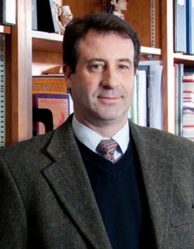 Matthew Bonner standing in front of bookcase. 