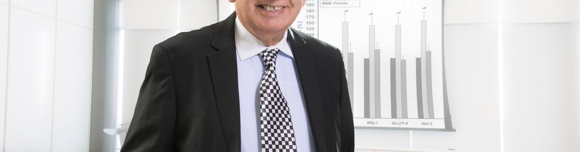 Paresh Dandona stands in an office. 