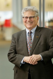 Zoom image: Photograph of Eaton Lattman standing outdoors in a suit and tie.