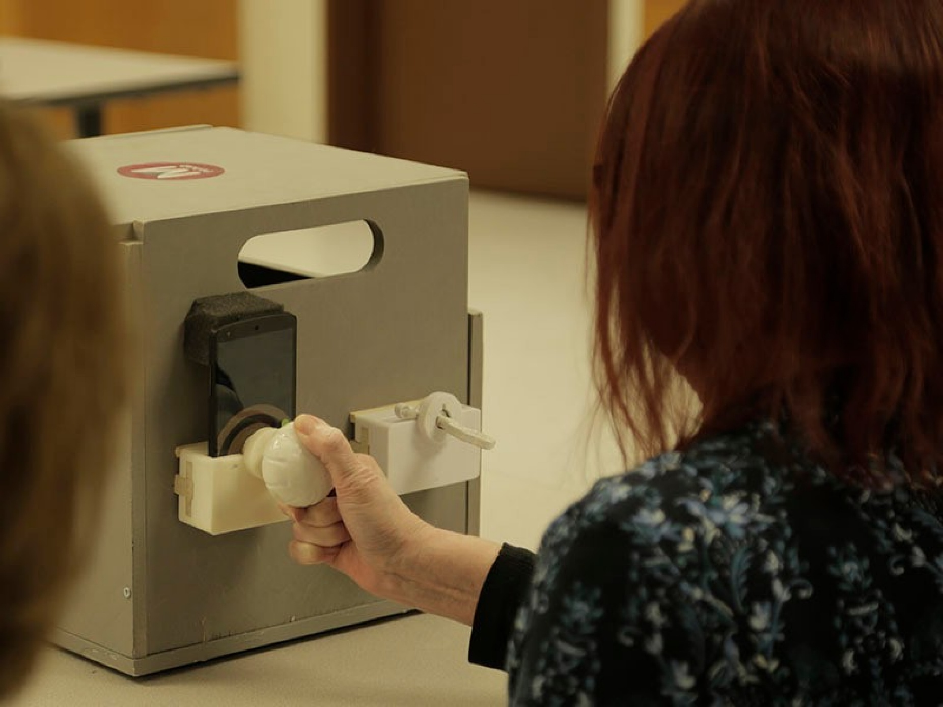An mRehab study participant turns the 3D-printed doorknob. 