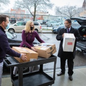 L to R Michael O'Hara and Heather Mattiuzzi of the Buffalo City Mission receive boxes from Praveen Arany. 