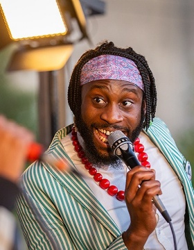 Photo of Michael Mwenso of Mwenso & the Shakes singing. 