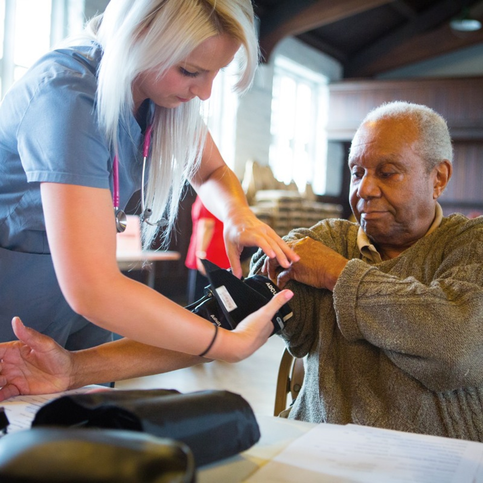 A nurse checks a man's blood pressure.