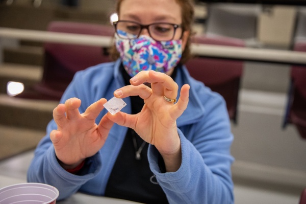 Zoom image: Ekin Atilla-Gokcumen, UB associate professor of chemistry and a repeat judge, examines a crystal. Credit: Meredith Forrest Kulwicki. Additional photos of the crystal contest judging are available for download. 