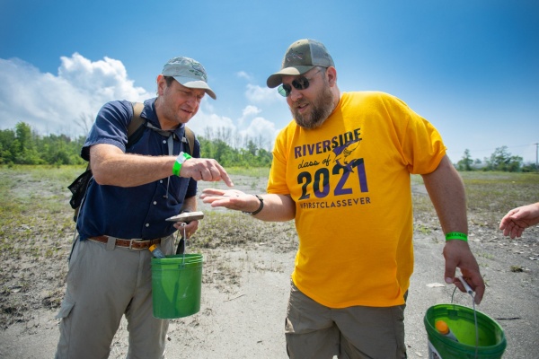 Zoom image: Paul Parrinello (left), Depew High School teacher, and Jerome Krajna, Riverside Academy teacher, investigate a specimen at Penn Dixie Fossil Park and Nature Reserve. Credit: Douglas Levere / University at Buffalo 