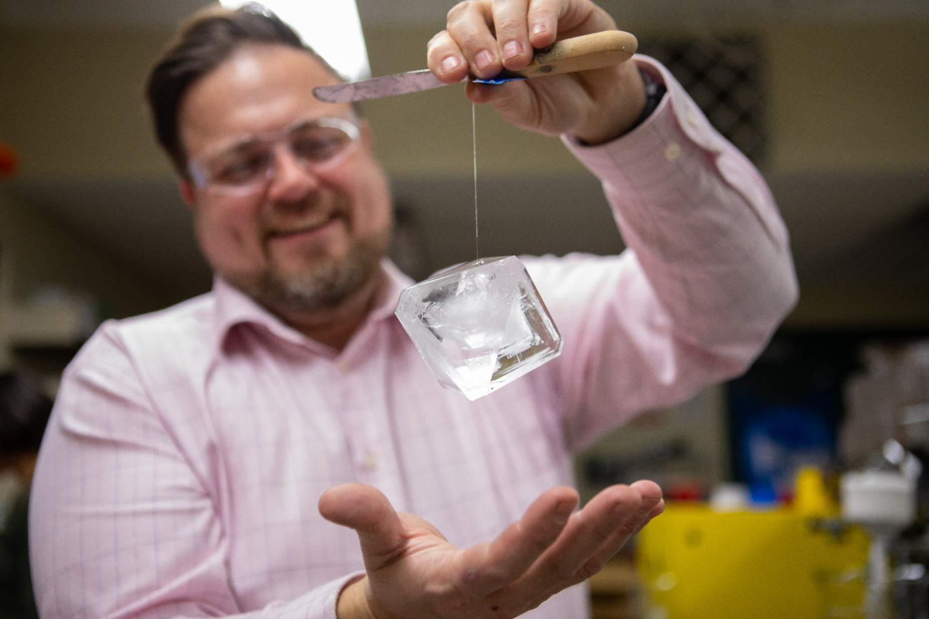 Zoom image: Big things are happening! UB chemist Jason Benedict, founder of the U.S. Crystal Growing Competition, shows off an enormous alum crystal. If you sign up for the contest, your crystal won't get this big (for the purposes of competition, growing time and the amount of crystal-growing material allowed are restricted). But your crystal could be just as beautiful and sparkly, and hopefully you'll have lots of fun! Credit: Douglas Levere / University at Buffalo 