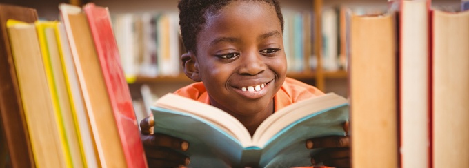 Photo of a Black child reading a book. 