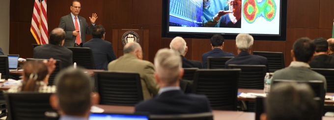 Satish Tripathi speaks in front of a crown at the workshop.