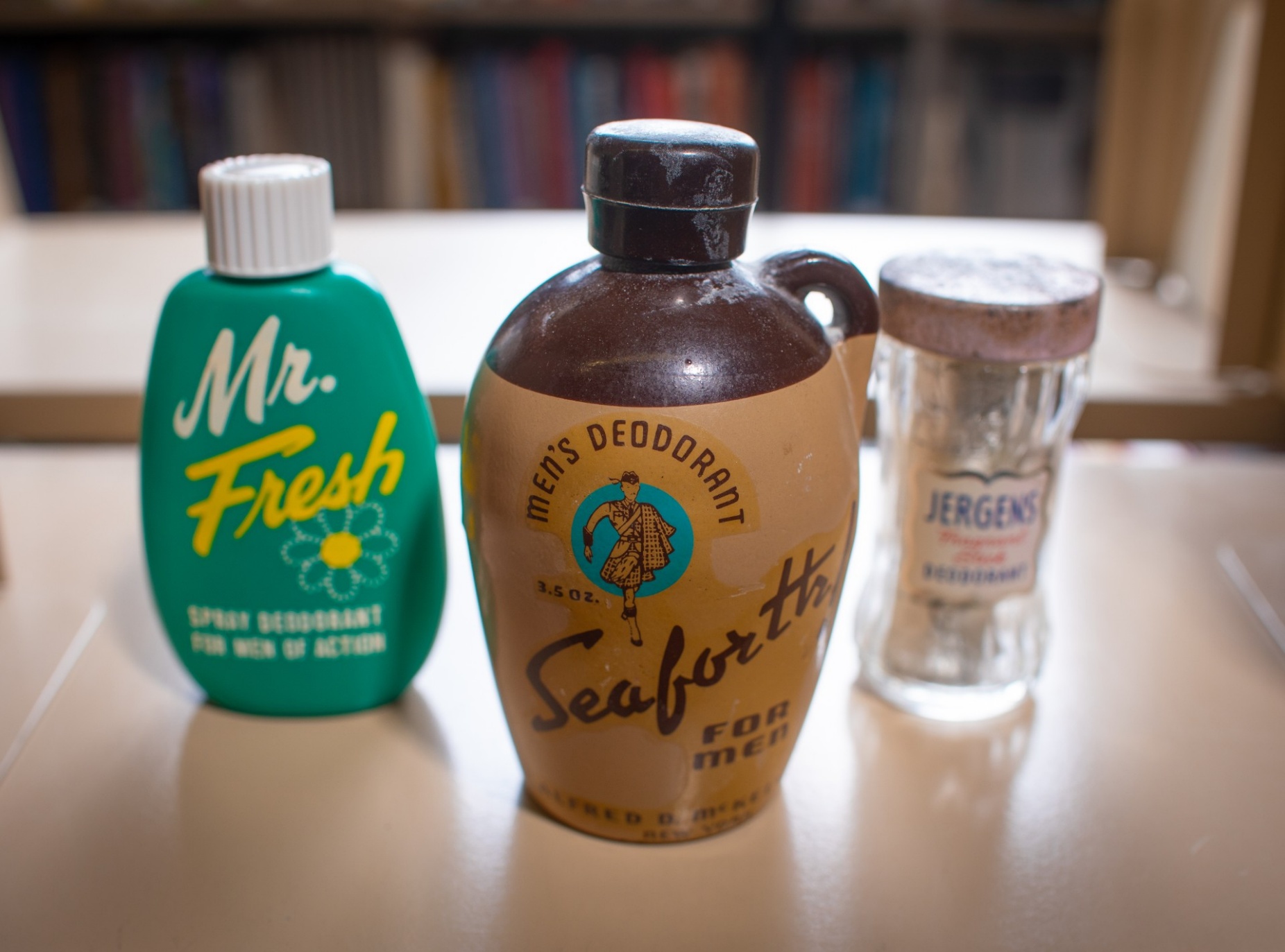Zoom image: A selection of now-obsolete deodorants sold in the 20th century, from the personal collection of Cari Casteel, University at Buffalo clinical assistant professor of history. From left to right: a circa 1950s Mr. Fresh spray deodorant; a circa 1940s Seaforth powder deodorant that was a gift from Casteel&rsquo;s brother; and a circa 1950s Jergens stick anti-perspirant. Casteel says the Jergens stick is super-fragrant, with a scent like baby powder, but that its active ingredient was found to be toxic. Credit: Douglas Levere / University at Buffalo 