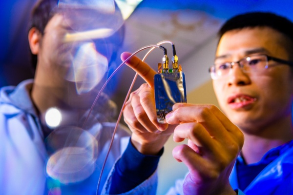 Zoom image: Yulong Huang (right) holds a lithium-ion battery with a cathode made from magneto-ionic material. Huang and Zheng Li (left), both UB postdoctoral researchers in mechanical and aerospace engineering, are among authors of a new study on the magneto-ionic material.&nbsp;Credit: Douglas Levere / University at Buffalo 