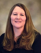 Portrait of Mary McVee, who has long hair and is wearing a dark shirt. 