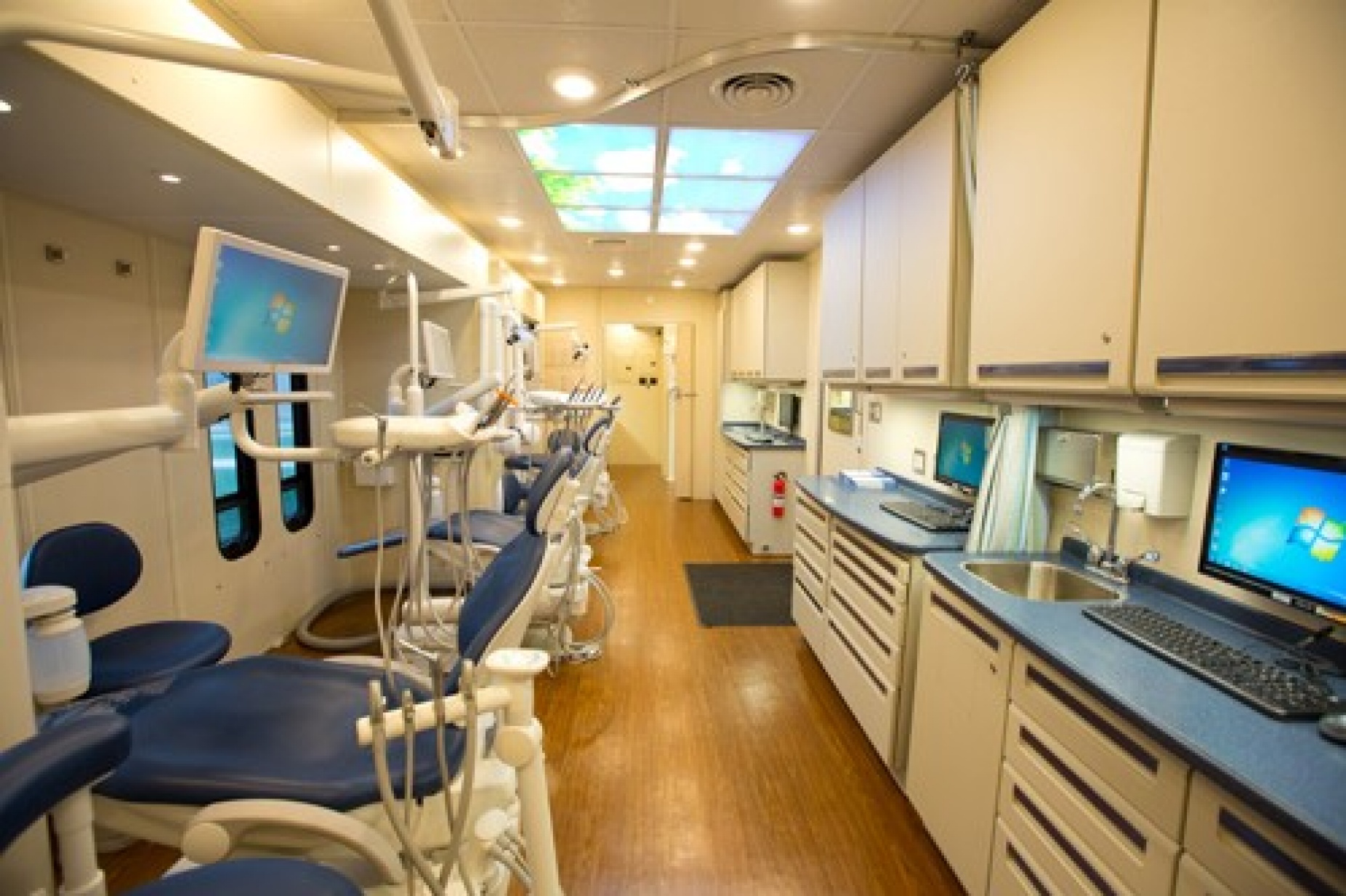 The inside of a mobile dental clinic, with dental chairs and equipment spread throughout the space. 