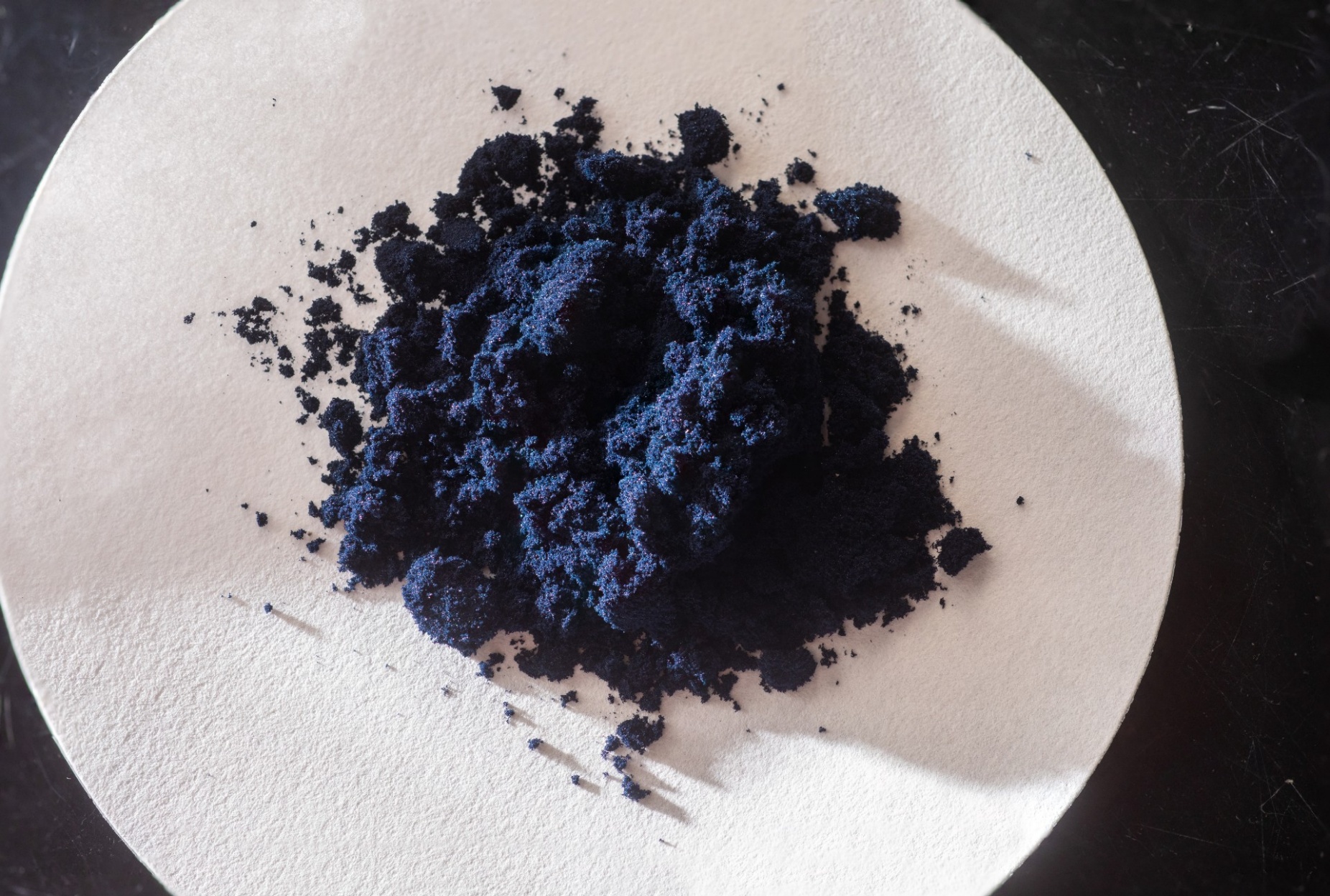 Zoom image: This midnight blue powder, MnCl3(OPPh3)2, provides scientists with a readily available source of manganese trichloride. This image is a composite that employs a technique called focus-stacking to show details more clearly. Credit: Douglas Levere / University at Buffalo 