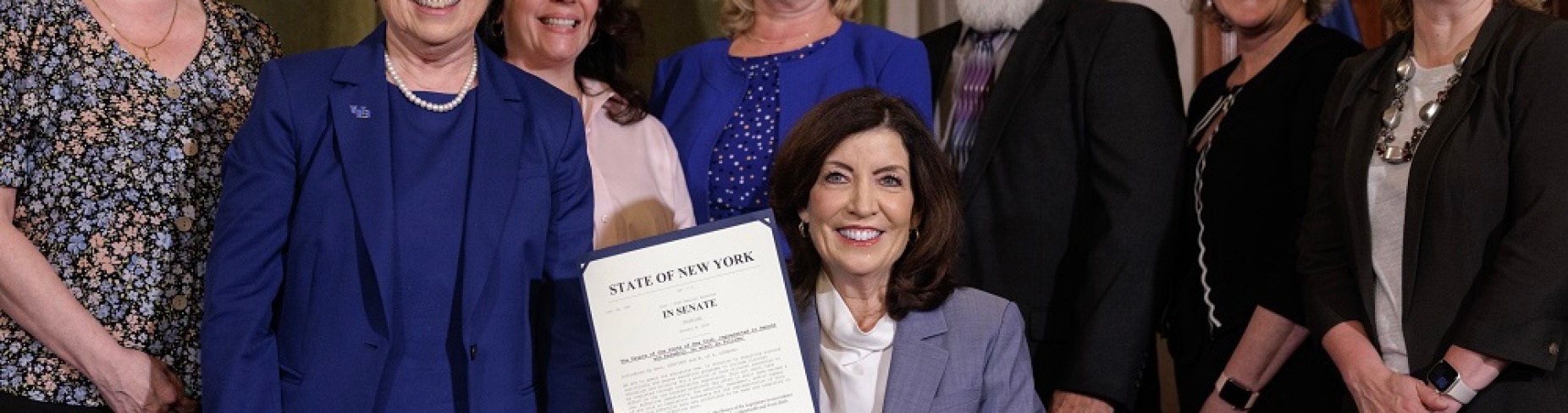Gov. Kathy Hochul was flanked by state nursing education leaders, including Annette Wysocki, dean of the University at Buffalo School of Nursing, as she shows a ceremonial bill she signed to increase nursing education simulation. 