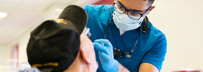 A dentist works on a veterans' teeth. 