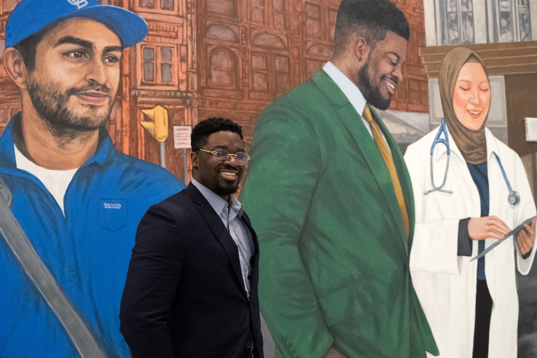 Daniel Olutalabi stands in front of his likeness in the mural. 