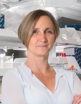 Headshot of Kinga Szigeti standing in a lab. 