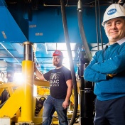 Andreas Stavridis, right, and a UB student stand under a shake table. 