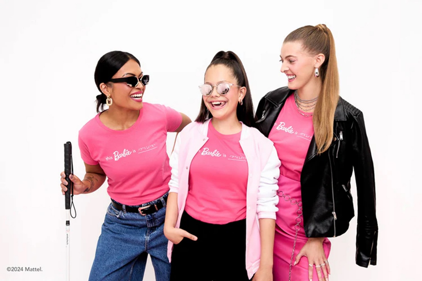 Three models posing together in Barbie apparel. 
