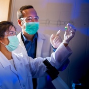 Three UB researchers work in a science lab. 