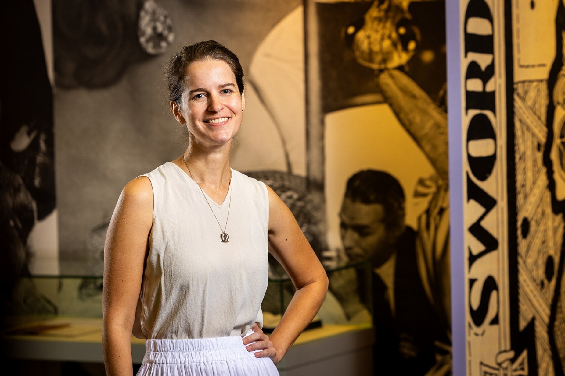 UB librarian Alison Fraser photographed standing in front of a new exhibit.
