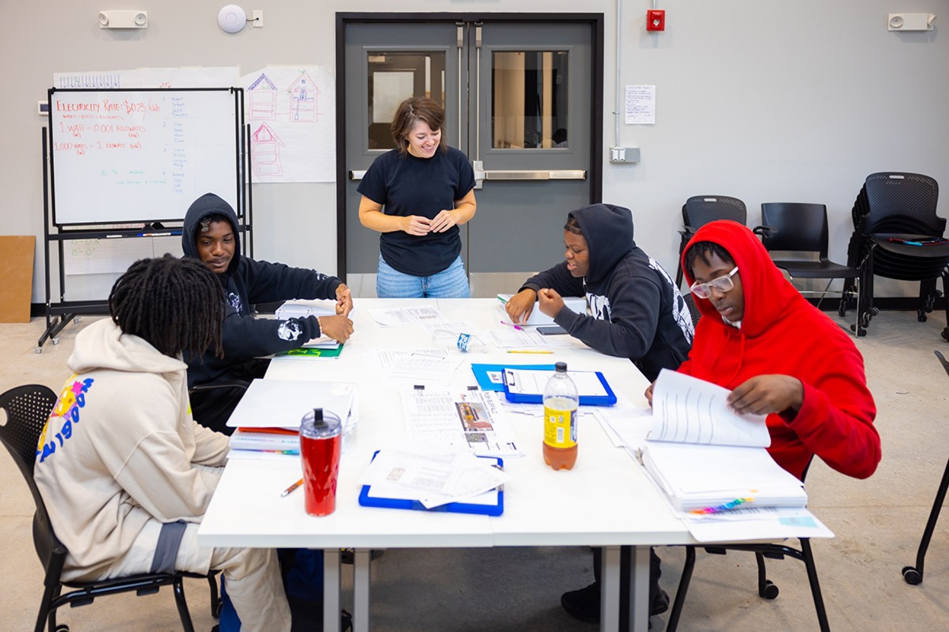 Zoom image: Laura Lubniewski, clinical assistant professor of architecture, gives instruction to, clockwise from top right, Nayaija Reid, David Clyburn, Shermarion Thomas and Seth Howard inside PUSH Buffalo's new Sustainability Workforce Training Center. Photo: Douglas Levere 