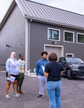 Zoom image: From left, students Tenesha Burnett, Jeffrey Campbell and David Dalrymple chat with UB's Laura Lubniewski. Photo: Douglas Levere 