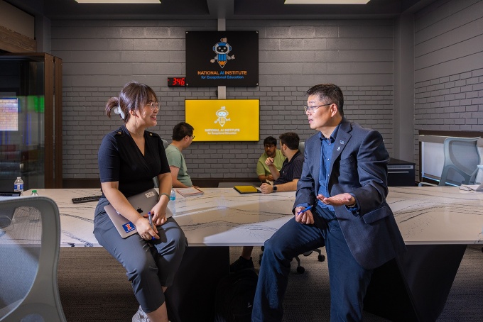 Zoom image: JinJun Xiong, with the department of computer science and engineering, meeting with students in the National AI Institute for Exceptional Education in Lockwood Library. Photo: Douglas Levere 