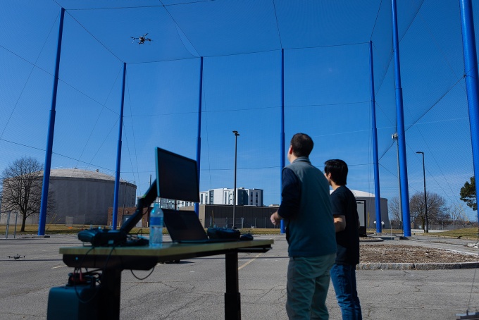Zoom image: Chase Murray and a student researcher fly a drone inside UB’s Structure for Outdoor Autonomy Research. Photo: Douglas Levere 