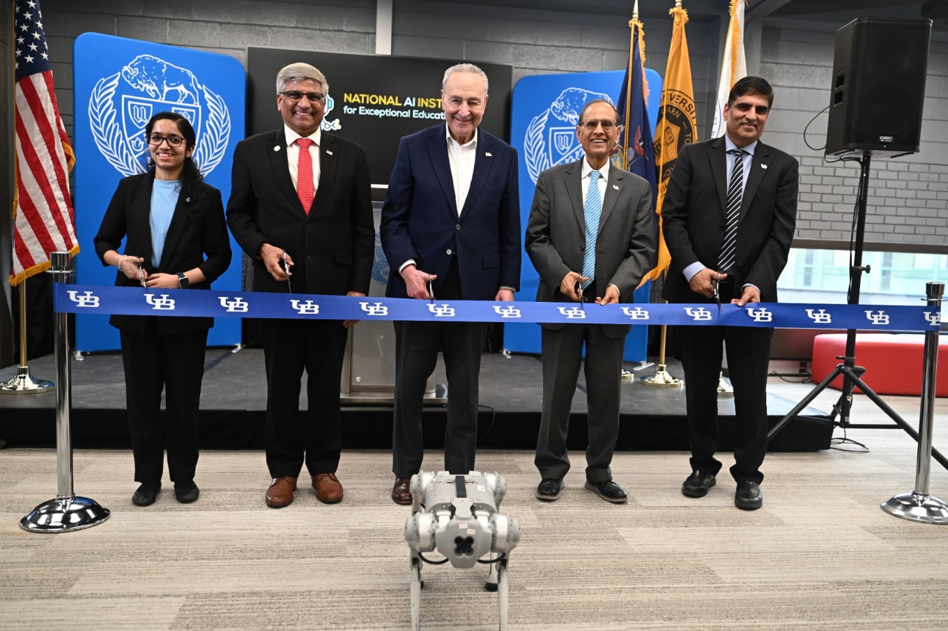 Zoom image: Preparing to cut the ribbon to open the National AI Institute for Exceptional Education are (from left) Sahana Rangasrinivasan, a computer science and engineering PhD candidate; NSF Director Sethuraman Panchanathan; U.S. Senate Majority Leader Chuck Schumer; President Satish K. Tripathi and Venu Govindaraju, vice president for research and economic development, and principal investigator of the AI institute. Photo: Nancy J. Parisi 