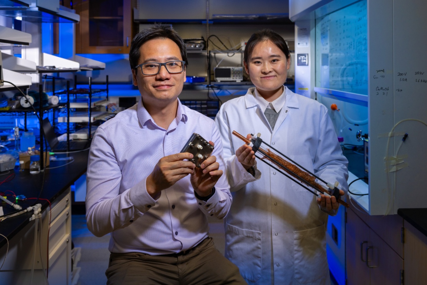 Zoom image: The reactor was developed by Li (from left) and study first author Xiaoli Ge, a postdoctroal researcher in Li's lab. Photo: Douglas Levere/University at Buffalo 